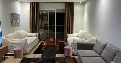 a living room with two couches and a table at Prestigia golf city bouskoura in Casablanca