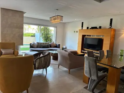 a living room with a couch and a television at Villa Bouznika Bay by Saloua in Bouznika