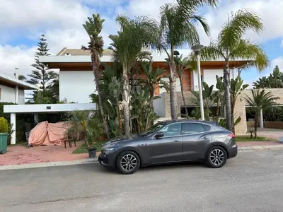 a gray car parked in front of a house at Villa Bouznika Bay by Saloua in Bouznika