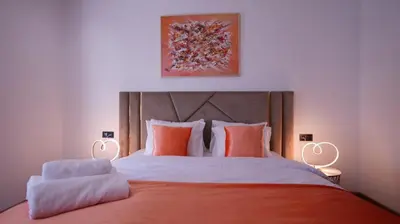 a bedroom with a large bed with orange sheets and pillows at Escapade Chic Gare - Oasis in Casablanca