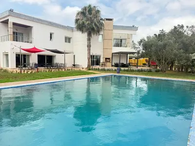 a swimming pool in front of a house at Asmae House in Skhirat