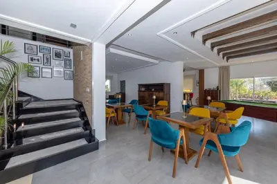 a dining room with tables and chairs and a staircase at Asmae House in Skhirat