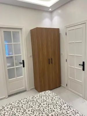 a bedroom with a wooden cabinet and two doors at Chic city center studio in Casablanca