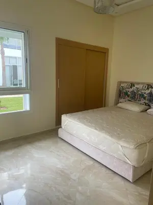 a bedroom with a large bed with a window at Casabay Sidi Rahal, à 2mn de la mer en bord de piscine et jardin in Sidi Rahal