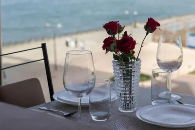a table with two wine glasses and a vase with roses at Studio prestige avec Terrasse sur la Marina in Casablanca