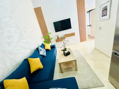 a blue couch in a living room with a tv at Casa Chic Studio Apartment in Casablanca
