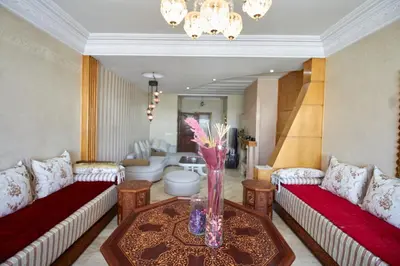 a living room with couches and a vase of flowers on a table at Appartement de luxe Résidence Du Palais GHANDI in Casablanca