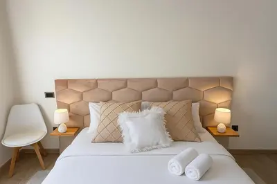a bedroom with a large white bed with two lamps at Cosy ensoleillé 2CH proche de Mosquee hassan II et corniche in Casablanca