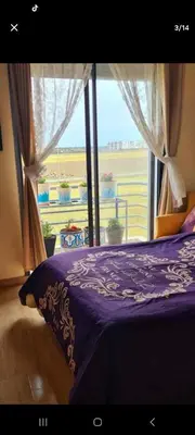 a bedroom with a purple bed and a window at Mansouria beach resort in Mohammedia