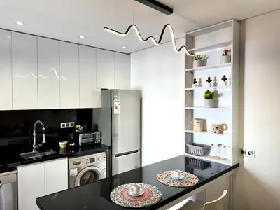 a kitchen with white cabinets and a black counter top at 2br near TGV station in Rabat