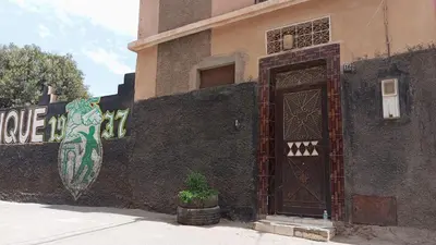 a building with a door and a plant in front of it at Appartements journaliers et mensuels in Aïn Chock
