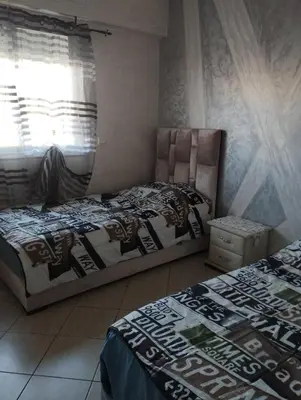 a bedroom with two beds and a window at appartement 75m2 avec piscine in Bouznika