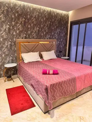 a bedroom with a large bed with a red blanket at Sunshine in Casablanca