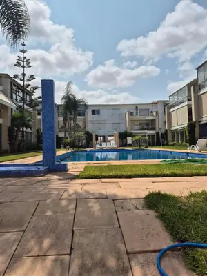a swimming pool in front of a building at Résidence balnéaire Les perles de Tamaris in Tamaris