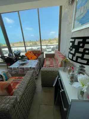 a living room with couches and a large window at Résidence balnéaire Les perles de Tamaris in Tamaris