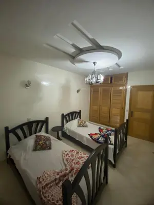 a bedroom with two beds and a chandelier at The Bright House in Casablanca