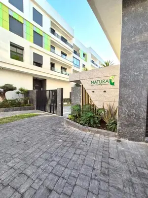 a parking lot in front of a building at Natura Living Apartment in Mohammedia