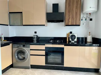 a kitchen with a washer and a washing machine at Natura Living Apartment in Mohammedia
