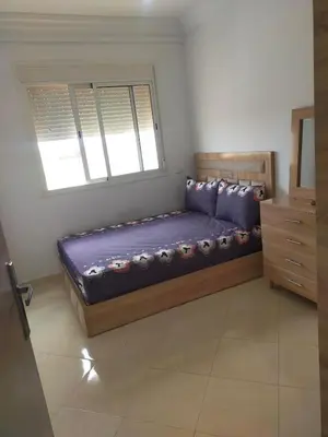 a bed in a room with a window at Appartement calme et confortable in Bouznika