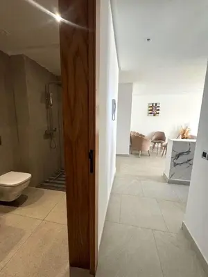 a bathroom with a shower and a toilet in a room at Sidi Rahal Oceanic Appartement vue sur piscine in Sidi Rahal