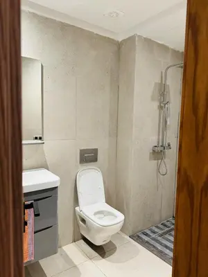 a bathroom with a toilet and a sink and a shower at Sidi Rahal Oceanic Appartement vue sur piscine in Sidi Rahal