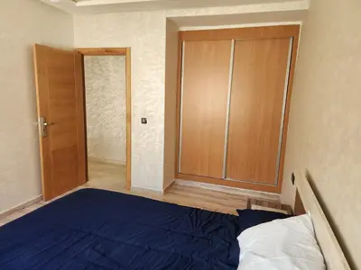 a bedroom with a blue bed and a closet at Bab fes Appartement 2 pièces à Aïn Sebaâ Casablanca in Aïn Sebaa