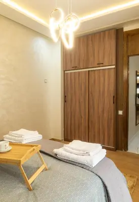 a room with a bed with a table and a closet at Charmant et cosy appartement en plein centre ville in Casablanca