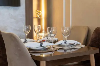 a wooden table with glasses and plates on it at Charmant et cosy appartement en plein centre ville in Casablanca