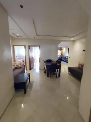 a living room with a table and a couch at Wifak beach rental in Temara