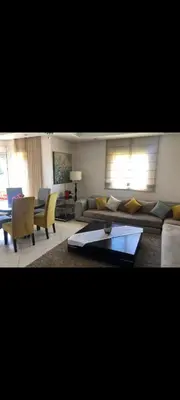 a living room with a couch and a table at Bahia golf beach pavillon in Bouznika