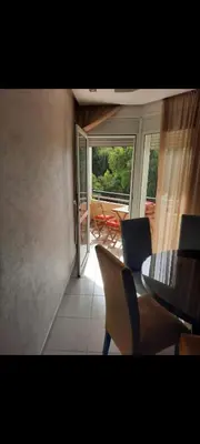 a dining room with a table and chairs and a balcony at Bahia golf beach pavillon in Bouznika