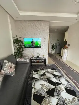 a living room with a couch and a television on a wall at Magnifique appartement à louer in Mohammedia