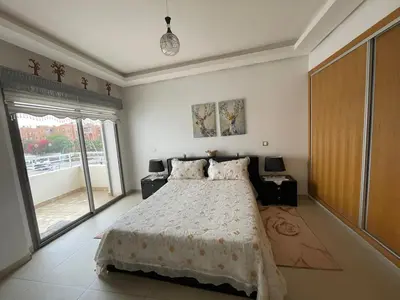 a bedroom with a bed and a large window at Magnifique appartement à louer in Mohammedia