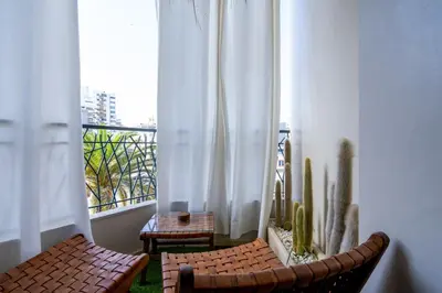 a balcony with two chairs and a window with a cactus at Central Cosy 2BR 2 Baths, Balcony & Clear View in Casablanca
