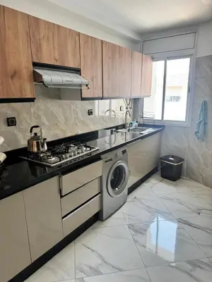 a kitchen with a stove and a washing machine at Elégant appartement 2 Bedroom près de la plage Rabat in Rabat