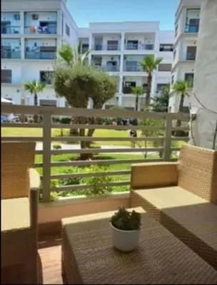a balcony with a table with a potted plant on it at Costa Beach 2 in Bouznika