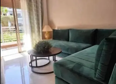 a living room with a green couch and a table at Costa Beach 2 in Bouznika