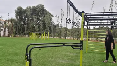 a woman walking in a park with a playground at Apartment with sea view in El Harhoura
