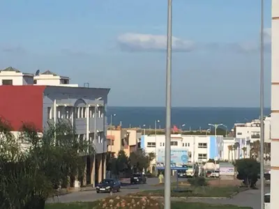 a city street with buildings and cars on the road at Apartment with sea view in El Harhoura