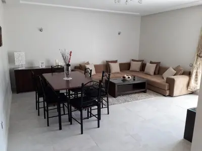 a living room with a table and a couch at Seaside apartment in El Mansouria in Mansouria