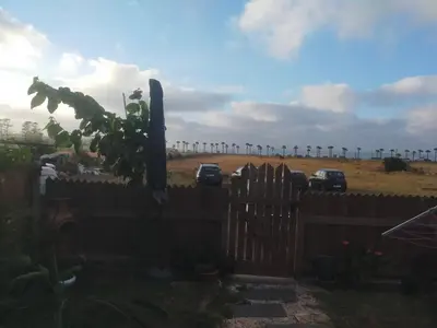 a fence with cars parked in a field with a cemetery at Birds House in Casablanca