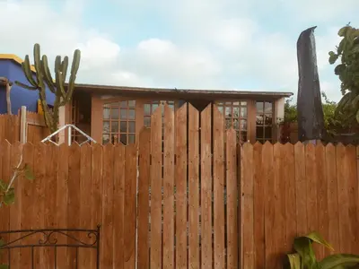 a wooden fence with a house behind it at Birds House in Casablanca