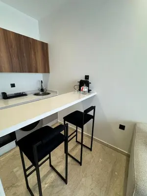 a kitchen with a counter and two chairs at a table at Beautiful apartment with a terrace in Casablanca