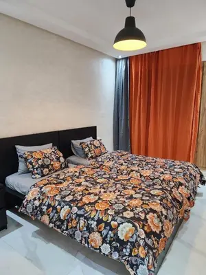 a bedroom with a bed with a floral comforter at Malaga el Mansouria valence in Casablanca