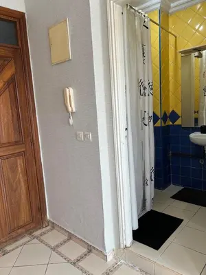 a bathroom with a shower with a phone on the wall at Un studio meublé agréable à Casablanca in Casablanca