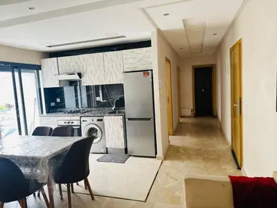 a kitchen and dining room with a table and chairs at Appartement vu sur mer in Pont Blondin