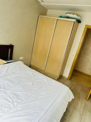 a bedroom with a bed and a wooden closet at Appartement vu sur mer in Pont Blondin