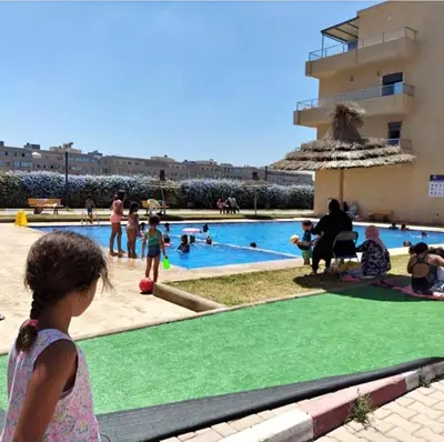 a little girl standing in front of a swimming pool at الشروق 2 in Mansouria