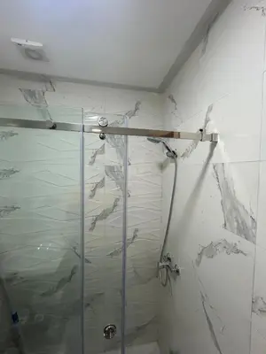 a shower with a glass door in a bathroom at Casablanca Luxury Studio Apartment Steps to the Beach in Casablanca