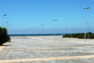 a large parking lot with street lights on the beach at Bahia Golf Beach Odyssée Appt Familial Bord De Mer in Bouznika